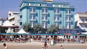 A beachfront hotel with multiple balconies, outdoor seating, and a clear view of the sea. - Hotel Gradara (Bellaria-Igea Marina)