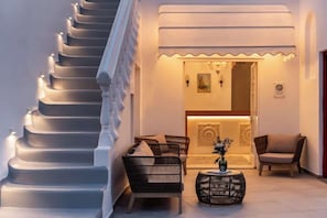 A staircase leading to a lobby with wicker furniture and a decorative wall. - Galation Hotel Mykonos (Mykonos)
