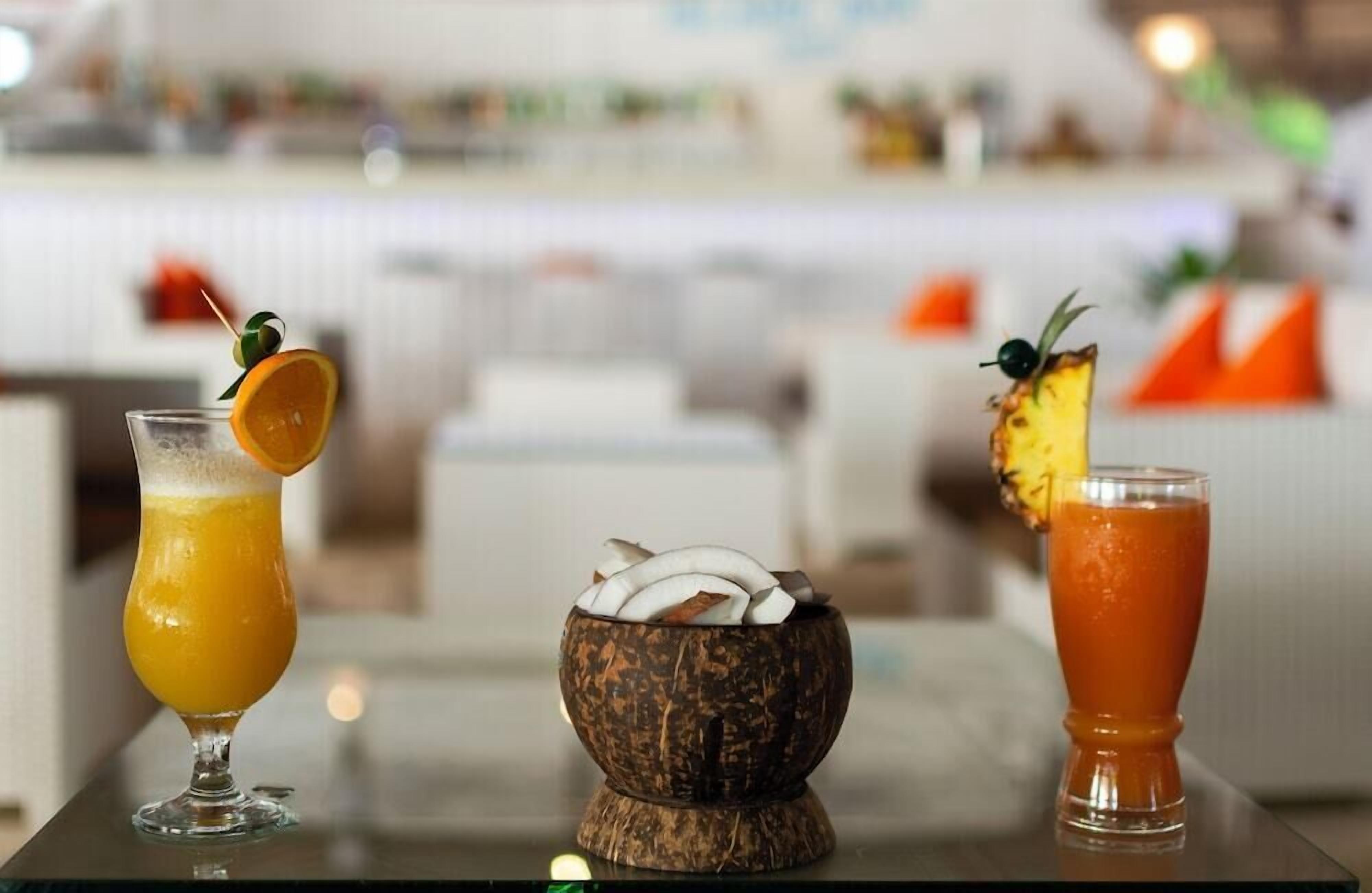 Three drinks on a table with a blurred background of a restaurant or bar setting.