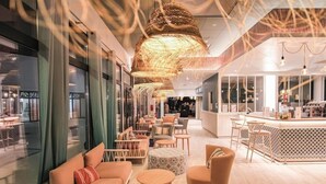 Un interior moderno con zonas de estar, un bar y vistas a la calle.