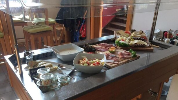 A buffet counter with various food items, including meats, salads, and desserts. - Bahnhof Balingen Hotel (Balingen)