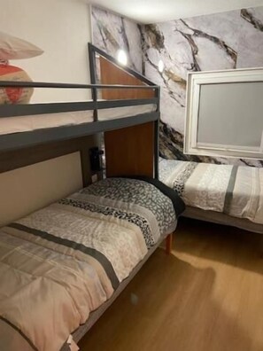 A bunk bed room with a marble-patterned wall, a wooden headboard, and a bedside table. - Hotel Classeco Gent (Ghent)