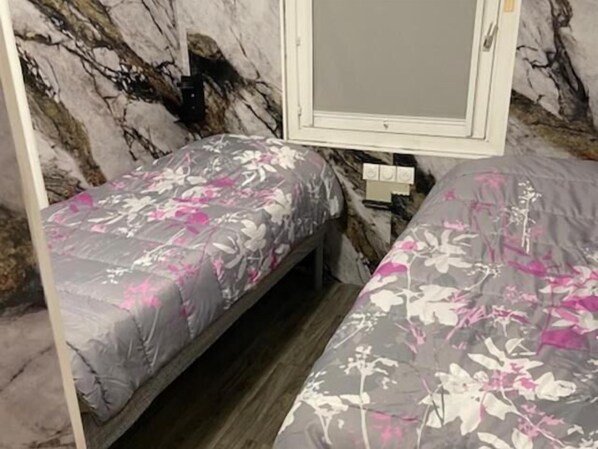A room with two beds, a marble wall, a mirror, and a power outlet. - Hotel Classeco Gent (Ghent)