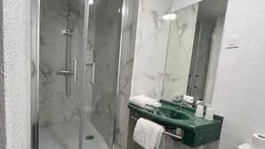 A bathroom with a glass-enclosed shower, a marble-tiled wall, a green sink, and a white toilet. - Hotel Classeco Gent (Ghent)