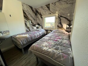 A small room with two single beds, a window, a sink, and a marble-patterned wall. - Hotel Classeco Gent (Ghent)