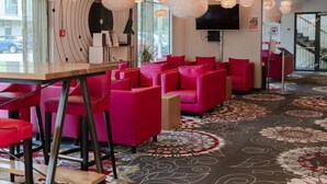 Ein modernes Interieur mit Barbereich, roten Sitzgelegenheiten und dekorativen Pendelleuchten.