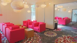 Ein moderner Lounge-Bereich mit roten Sofas und einem gemusterten Teppich.