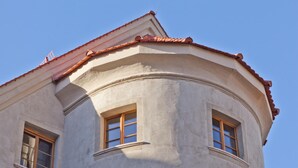 A corner of a building with a curved facade and two windows. - Hotel David (Regensburg)