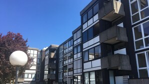 A modern multi-story building with a mix of large windows and balconies. - Modern Hoteliving Giessen (Pohlheim)