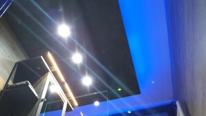 A modern interior with a sloped ceiling, recessed lighting, and a visible staircase. - Modern Hoteliving Giessen (Pohlheim)