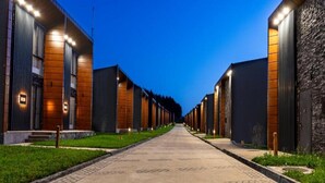A row of modern buildings with a central pathway, likely part of a hotel or resort. - Kass Diamond Resort (Tsalka)