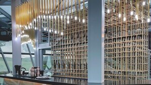 A modern interior with a glass partition, metal shelving, and hanging lights. - Kass Diamond Resort (Tsalka)