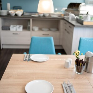 A dining table set with plates, cutlery, and a glass of chocolate. - Lahn Hotel (Biedenkopf)