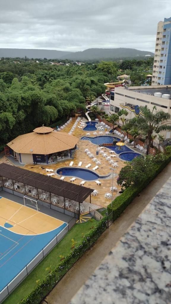 Zona de piscina exterior con varias piscinas, sillas de descanso y un área de estar cubierta.