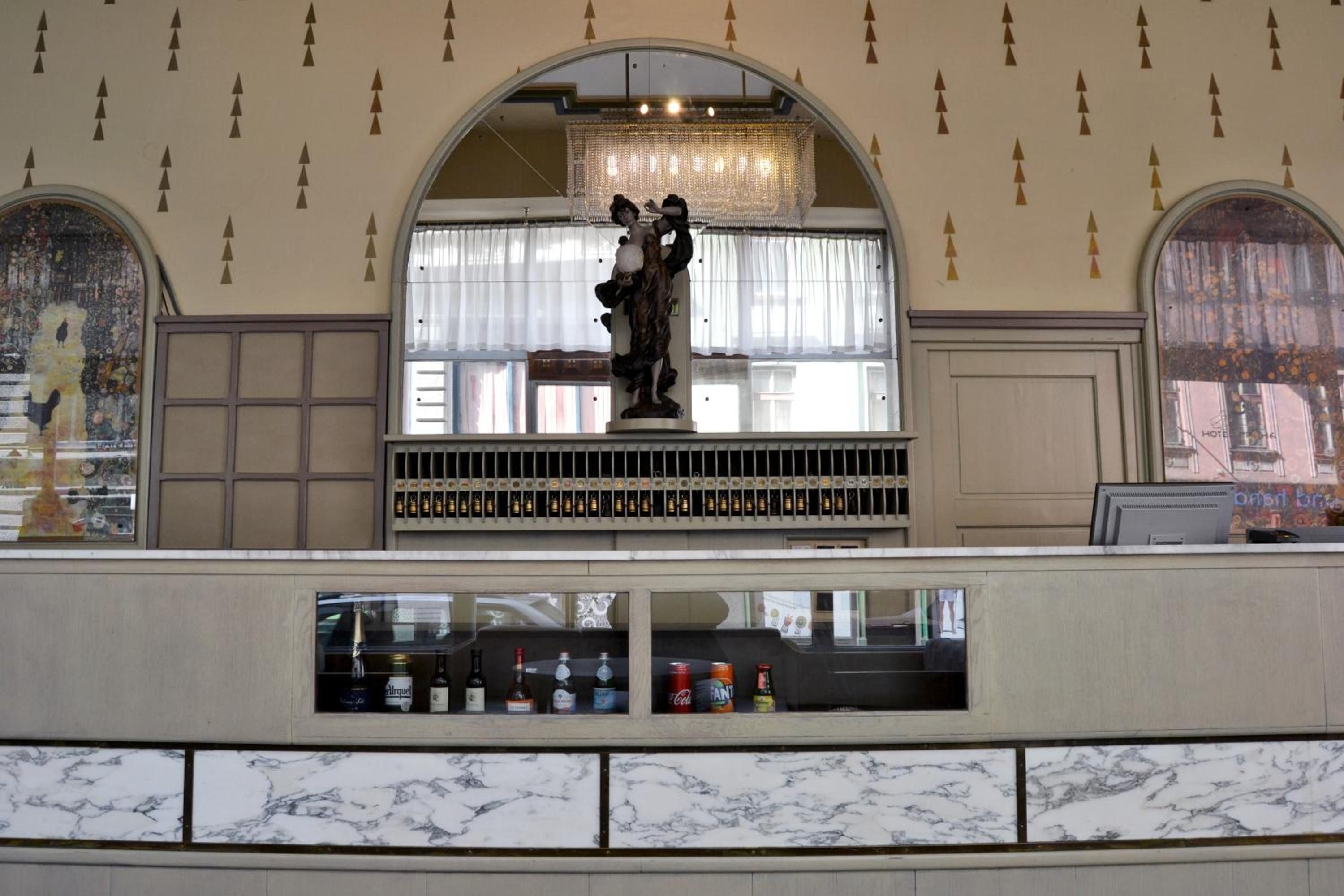 A bar area with a statue, a wine rack, and a marble-tiled counter.