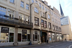Un edificio de varios pisos con una cafetería en la planta baja y un hotel en el segundo piso.