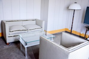 A room with a sofa, a glass coffee table, and a lamp. - Hotel Praha Liberec (Liberec)