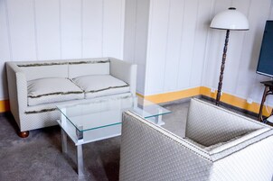 Una habitación con un sofá, una mesita de cristal y una lámpara.