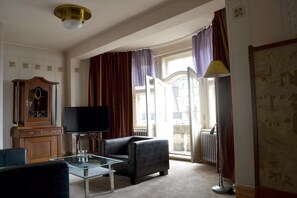 Een woonkamer met een televisie, een bank en een glazen salontafel.