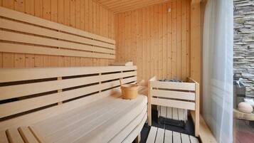 Una sauna de madera con bancos y una pared de piedra.