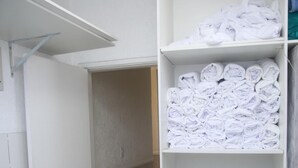 A hotel bathroom with a white sink, a towel rack, and a shelf with neatly folded towels. - Hotel Jurubatuba (São Bernardo do Campo)