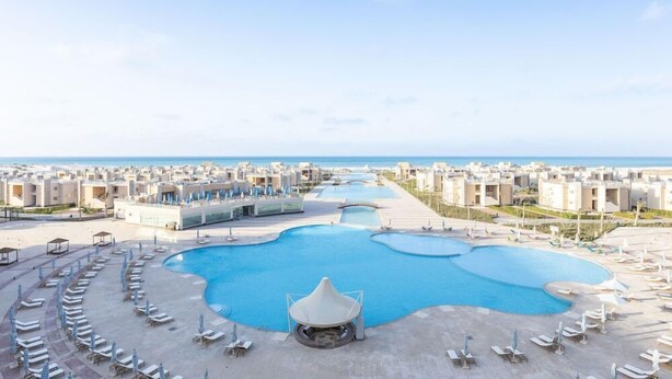 A resort with a large central pool, multiple smaller pools, and a beach area with sun loungers. - Gewan Resort New Alamein (El Alamein)
