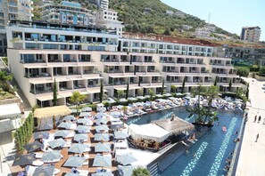 Un hôtel doté de nombreux balcons, d’une piscine et d’espaces de détente en plein air.