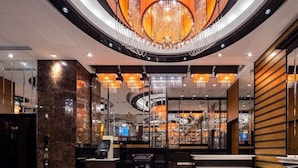 A modern hotel lobby with a grand chandelier, marble flooring, and a reception desk. - Apa Hotel (Tokyo)