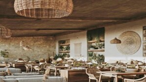 A rustic dining area with wooden tables and chairs, wicker hanging lights, and shelves with plants. - Dream of Zanzibar (Uroa)