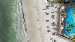 A beachside hotel with a swimming pool, sun loungers, and palm trees. - Dream of Zanzibar (Uroa)