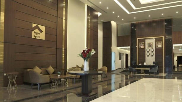 A modern lobby with a reception desk, seating area, and a large marble floor. - Swiss Spirit Hotel and Suites Dammam (Dammam)