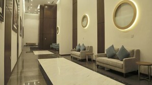 A modern lobby with a marble floor, sofas, and a bench. - Swiss Spirit Hotel and Suites Dammam (Dammam)