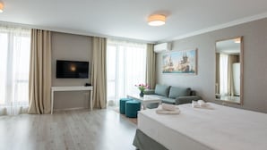 Ein modernes Hotelzimmer mit einem großen Bett, einem Schreibtisch, einem Fernseher und einem Gemälde an der Wand.