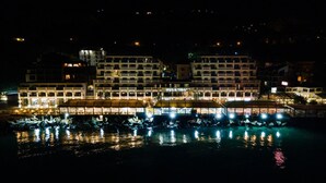 Ein Hotel am Wasser mit mehreren Balkonen und einem Poolbereich.