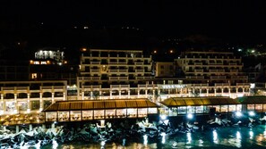 A waterfront hotel with multiple buildings, a covered walkway, and a pool area. - Maria Palace Hotel (Balchik)