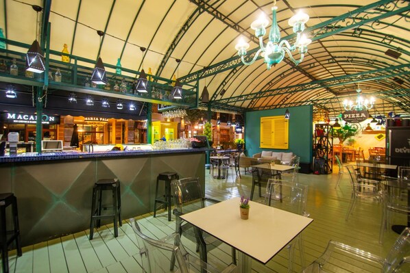 An indoor restaurant with a high arched ceiling, clear glass tables, and a variety of seating options. - Maria Palace Hotel (Balchik)