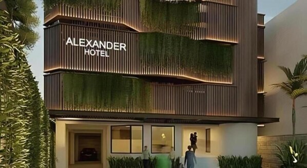 Un hotel moderno con un letrero llamativo que dice 'ALEXANDER HOTEL'.