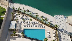 An aerial view of a resort with a swimming pool, sun loungers, and a beach area. - Intercontinental ABU Dhabi Residence (Abu Dhabi)