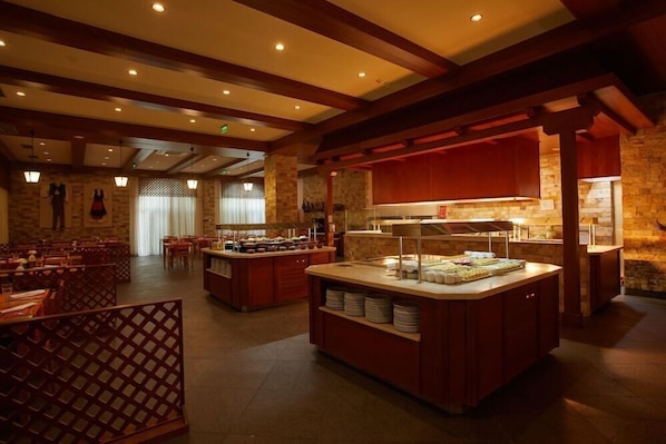 A buffet area with a central island, wooden beams, stone walls, and a seating area with tables and chairs. - Alua Sunny Beach Resort & Spa (Nessebar)