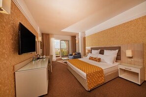 Une chambre d’hôtel équipée d’un lit, de tables de chevet, d’un téléviseur à écran plat, d’un bureau et offrant une vue sur l’extérieur.