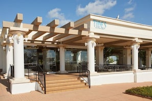 A building with a covered outdoor seating area, columns, and a staircase leading to the entrance. - Alua Sunny Beach Resort & Spa (Nessebar)