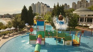 A water park with slides and a pool, surrounded by trees and buildings. - Alua Sunny Beach Resort & Spa (Nessebar)