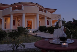 Un edificio grande y elegante con fachada curva, múltiples columnas y un balcón.