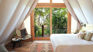 A tented room with a bed, a chair, and a view of greenery outside. - Our Habitas Bacalar (Bacalar)