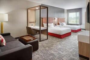 A hotel room with a desk, two beds, a sofa, and a large window. - Springhill Suites Franklin Mint (South Portland)