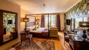 A bedroom with a large bed, a desk, a chair, a mirror, and a window with curtains. - The Bears Paw Inn (Sandbach)