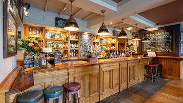 Un bar con banconi in legno, luci a sospensione e una lavagna con il menu.