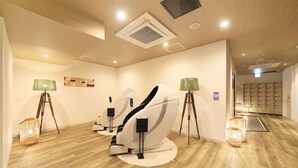 Een moderne spa ruimte met massagestoelen, een houten vloer en een wandunit voor airconditioning.