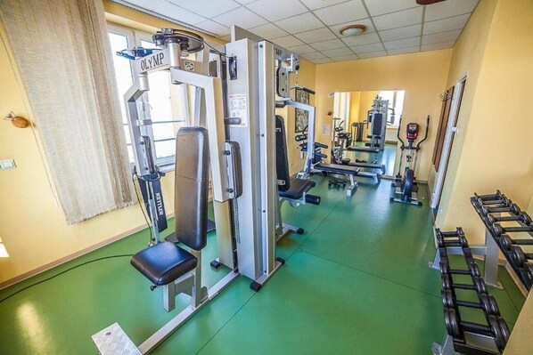 A gym with various exercise equipment, including weight machines and dumbbells. - Hotel Rychlo (Bogatynia)