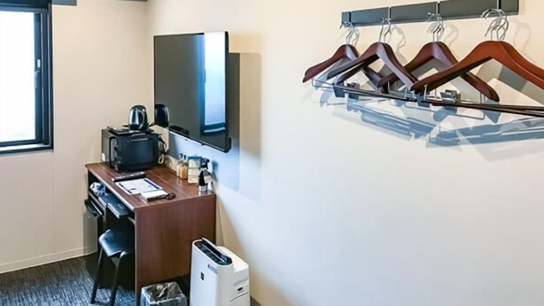 A hotel room with a desk, a flat-screen TV, a coffee maker, a trash bin, and a wall-mounted coat rack. - Hotel Live Max Nagoya Sakuradoriguchi (Nagoya)